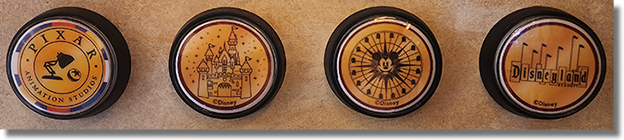 The Magic Key Terrace Medallion Machine Buttons Set #90, 92, 156, 93. Pixar Animation Studios, Disneyland Castle, Pixar Pal-A-Round (2001 Sun Wheel, 2008 Mickey's Fun Wheel), and the classic Seven-Flag Disneyland Sign. 4-26-2024.